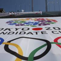 Still burning: The Olympic cauldron, used in the 1964 Tokyo Summer Games, stands above a huge banner bearing the official logo for the capital’s bid to host the 2020 Olympics that has been spread over the grandstands at National Stadium. Experts uncertain about Tokyo bid