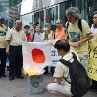 Memories fresh: Protesters burn a Hinomaru flag during an anti-Japanese rally in Hong Kong on Aug. 15 to mark the anniversary of Japan\'s surrender in World War II in 1945. On Sunday, turnout was small for a protest march held to condemn Japan\'s effective nationalization last year of the disputed Senkaku Islands. | KYODO