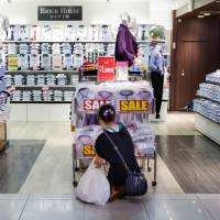Spend or save?: Shoppers check out shirts at a store beneath Tokyo station on Sept. 8. 50% against hiking sales tax in April: poll