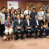 Tourist snapshot: International students pose for a photo with senior vice tourism minister Yosuke Tsuruho (seated, center) and others following a roundtable meeting on Japan\'s tourism strategy Wednesday in Tokyo. | JUN HONGO