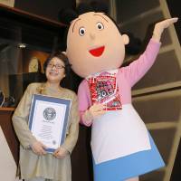 Voice behind the face: Midori Kato, who dubs the voice of cartoon character \"Sazae-san\" on the animated TV series of the same name, poses earlier this month with a mascot of the character. | KYODO