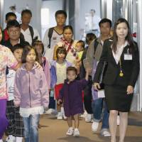 Yokoso Japan: Four Myanmar families from a refugee camp in Thailand arrive at Narita airport Friday evening to begin their new lives in Japan under a U.N. resettlement program. | KYODO