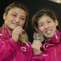 Midas touch: Kaori Icho (left) and Saori Yoshida hold their medals after winning gold at the world wrestling championships in Budapest on Thursday.  | KYODO