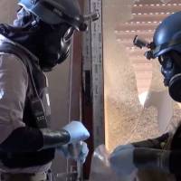 Probing for proof: Members of a U.N. team take samples from the ground in the Damascus area of Zamalka on Aug. 29 in this image taken from video obtained from the Shaam News Network. | AP