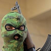 In plain sight: A Syrian rebel fighter takes part in a protest against the regime of President Bashar Assad in the northern city of Aleppo last October. Assad\'s forces are defending Damascus and territory in the west and center of the country, while rebels control the north and east. | AFP-JIJI