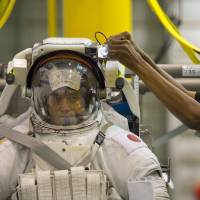 The helmet and gloves of an astronaut\'s Extra Vehicular Activity suit rest on the pool deck inside the Neutral Buoyancy Laboratory at the Lyndon B. Johnson Space Center in Houston. Astronauts tapped for service on the ISS train under water | THE WASHINGTON POST