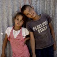 No age of innocence: Syrian siblings pose for a photograph near their tent at a refugee camp in the eastern Lebanese border town of al-Faour on Wednesday. | AP