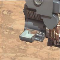 Scratching the surface: The Curiosity rover holds a scoop of powdered rock on Mars before analyzing its chemical makeup in March. | AP