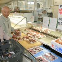 Shoppers choose fish at a supermarket in Soma, Fukushima Prefecture, on Thursday, the day after the local fisheries cooperative resumed trial operations that had been suspended over the July disclosure of radioactive water leaks into the sea from the Fukushima No. 1 power plant. | KYODO