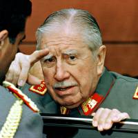 Usurper: Gen. Augusto Pinochet talks to an attendee at a military school parade in Santiago, Chile, on Aug. 23, 1997. U.S. role in aiding Pinochet