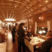 First-class fare: Foreign media members try out the services in the dining car of the Seven Stars luxury train during a recent demonstration run by Kyushu Railway Co. | JR KYUSHU/KYODO