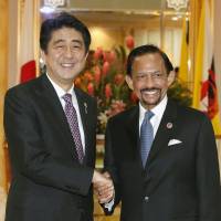 Power shake: Prime Minister Shinzo Abe and Sultan Hassanal Bolkiah of Brunei shake hands ahead of their meeting in Brunei on Wednesday. | KYODO