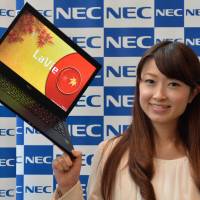 Light as a leaf: A model holds up NEC Personal Computer Ltd.\'s 795-gram Lavie Z LZ750/NS, the world\'s lightest 13.3-inch notebook computer, in Tokyo on Tuesday. | AFP-JIJI