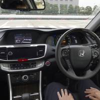 Look mom, no hands: An employee “drives” a Honda Accord hybrid with an automatic driving system at the ITS World Congress Tokyo 2013 on Tuesday. Race is on to develop self-driving autos