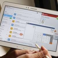 Email glut: Employees in modern times instinctively reach for their mobile devices to scroll through inboxes even though they are on vacation, making sure the world continues to function in spite of their absence. | AP