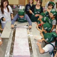 Roll with it: Elementary school students and their parents create the world\'s biggest piece of chewing gum Saturday in Sapporo, setting a new Guinness world record. | KYODO