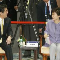A start: Prime Minister Shinzo Abe and South Korean President Park Geun-hye chat Tuesday while attending the Asia-Pacific Economic Cooperation forum summit in Bali, Indonesia. | KYODO