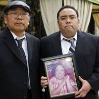 Crash loss: Jeffrey Uno holds a photo of his late mother, Noriko, as his father, Peter, looks on in February 2010. Toyota wins first acceleration trial
