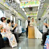 Tying the loop: Guests applaud newlyweds Nobuhiko Suzuki and Sayaka Tsuchiya during their wedding ceremony aboard a specially chartered Yamanote Line train in Tokyo on Monday. | KYODO