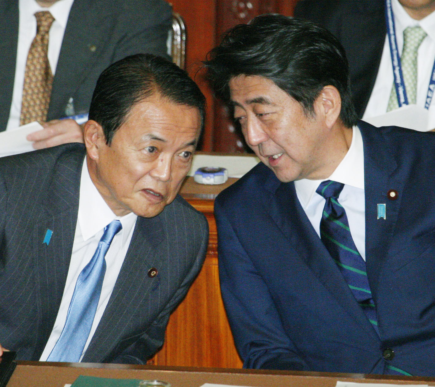 Don't panic: Prime Minister Shinzo Abe (right) chats with Finance Minister Taro Aso during a Lower House session Wednesday. Abe told the session the mounting accumulation of radioactive water at the crippled Fukushima No. 1 nuclear plant is a situation that is 'under control.' | KYODO