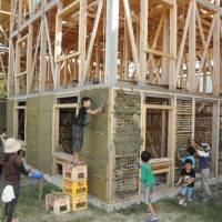 Hands-on training: Kids help build the soil-and-bamboo wall of the Home-for-all guest house at Aioiyama Tokurinji Temple in Tenpaku Ward, Nagoya, earlier this month. | CHUNICHI SHIMBUN