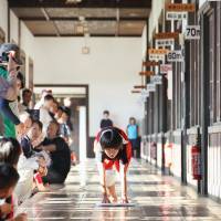 Cleanup: A child pushes a duster along a hallway during a cleaning race held in Seiyo, Ehime Prefecture, on Friday. | KYODO