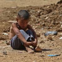 One in a million: A Syrian boy sits on the ground at a temporary refugee camp in the eastern Lebanese town of Al-Faour, near the border with Syria, on Sept. 11 | AP