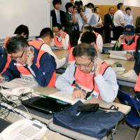 This is just a test: Ehime prefectural officials work the phones during a disaster drill for a radiation leak at the Ikata nuclear power plant in Ehime Prefecture | KYODO
