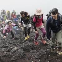 Tracking their whereabouts: People scale the slopes of Mount Fuji on June 30, the day before the annual climbing season opened. Dismissing privacy concerns, the Japan Tourism Authority plans to use location data collected from mobile phone users to track the movements of tourists | KYODO