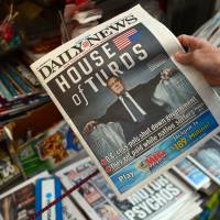 Douche: A woman buys a copy of the New York Daily News featuring a photo of U.S. House Speaker John Boehner on Tuesday, following a shutdown of the federal government. | AFP-JIJI