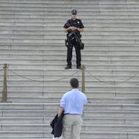 Impasse: A man speaks with police outside the U.S. Capitol in Washington on Tuesday, after the federal government largely shut down because Congress remains deadlocked over the budget and the Affordable Care Act. | THE WASHINGTON POST
