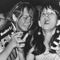 Mixed emotions: Two girls watch the Beatles perform in Philadelphia on Aug. 16, 1966. Barricades manned by policemen were erected about 50 meters from the stage in an effort to keep the band’s young fans from rushing the “Fab Four.” Beatlemania: 'The screamers' and other tales of fandom