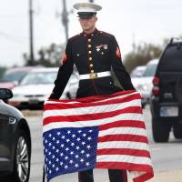 Signaling his displeasure: A U.S. Marine veteran shows his concern over the government shutdown by holding an American flag upside down, a signal of distress, in Beech Grove, Indiana, on Tuesday. | AP