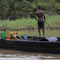 Black gold: Suspected thieves pilot a boat loaded with a cargo of stolen crude oil in Bayelsa, Nigeria. According to one oil trader: \"All the authorities are involved &#8212; the oil companies, the military, the politicians. There\'s plenty of money to be made.\" | AP