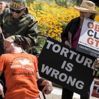Choking anger: Activists re-enact the force-feeding of prisoners at Guantanamo Bay during a July 30 protest in Washington. | AFP-JIJI