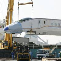 A lead car of the new E7 series of bullet trains arrives at Shiogama port in Sendai on Wednesday before being transported to East Japan Railway Co.\'s maintenance depot in Rifu, Miyagi Prefecture, for checks and tests. The E7s are scheduled to start running between Tokyo and Nagano next year, and from Nagano to Kanazawa in 2015. | KYODO