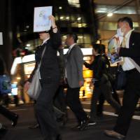 Dress for protests: People wearing suits walk through the Shinbashi district in Tokyo\'s Chiyoda Ward on Wednesday during the anti-nuclear demonstration named Suit Demo. Participants were encouraged to wear their office attire in the after-work rally. | SATOKO KAWASAKI