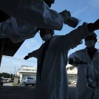 Next nightmare: A worker is screened for radiation in Minamisoma after leaving the 20-km exclusion zone around the wrecked Fukushima No. 1 nuclear power plant in September 2011. | BLOOMBERG