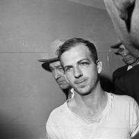 Lee Harvey Oswald is escorted through the Dallas police station on Nov. 23, 1963. Oswald would be gunned down by Jack Ruby the next day. | AP