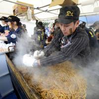 Fried to perfection: A participant from Namie, Fukushima Prefecture, cooks up a batch of fried noodles Sunday at the B-1 Grand Prix contest in Toyokawa, Aichi Prefecture. | KYODO