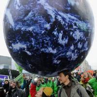 The world is ours: Activists march to campaign against global warming Saturday in Warsaw, where a United Nations conference is discussing a new climate deal | AP/KYODO