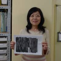 Redacted: At the Hoshino Defense Committee office in Tokyo, Akiko Hoshino holds up a letter from her husband that was blacked out by prison authorities. | WILLIAM ANDREWS
