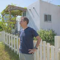 The island life: Keith Gordon stands outside his home in Kunigami in northern Okinawa.  The grounds are spacious enough to accommodate a kitchen garden, home music studio and patio area. | STEPHEN MANSFIELD