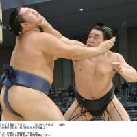 Get a grip: Harumafuji (right) holds Tochinokawa at bay at the Kyushu Grand Sumo Tournament in Fukuoka on Monday. | KYODO