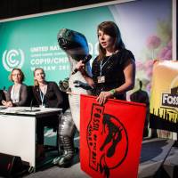 Heated moment: A member of the activist group Climate Action Network announces Friday at climate talks in Warsaw that Japan was being given the Fossil of the Day Award for slashing its goal for reducing greenhouse gas emissions. | AFP-JIJI