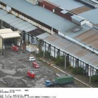 Aftermath: Fire engines and other emergency vehicles sit out in front of the factory at the Nippon Steel and Sumitomo Metal Corp. Yahata plant in Fukuoka Prefecture on Monday, where an explosion killed one worker and injured two others. | KYODO