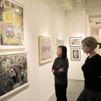 Bird\'s-eye view: Midori Kano (left), assistant director of Cavin-Morris Gallery in New York, and a visitor view owl-themed paintings by disabled artists from countries including Japan, Nepal, South Korea and Italy on Oct | 23 DURING AN EXHIBITION TITLED \"FUKURO: OWLS OF HAYASHIBARA, JAPAN.\"  KYODO