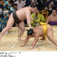 Rolling along: Yokozuna Hakuho reminds Shohozan of his prowess in the raised ring on Saturday at the Kyushu Grand Sumo Tournament | KYODO