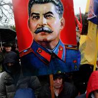 Sending a message: A man holds up a portrait of former Soviet dictator Josef Stalin as activists of various Russian nationalist movements take part in a rally during the National Unity Day in St. Petersburg on Nov. 4 | AFP-JIJI