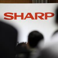 Making changes?: The Sharp Corp. logo appears on a wall during the unveiling of its new TVs in Tokyo in May. | BLOOMBERG